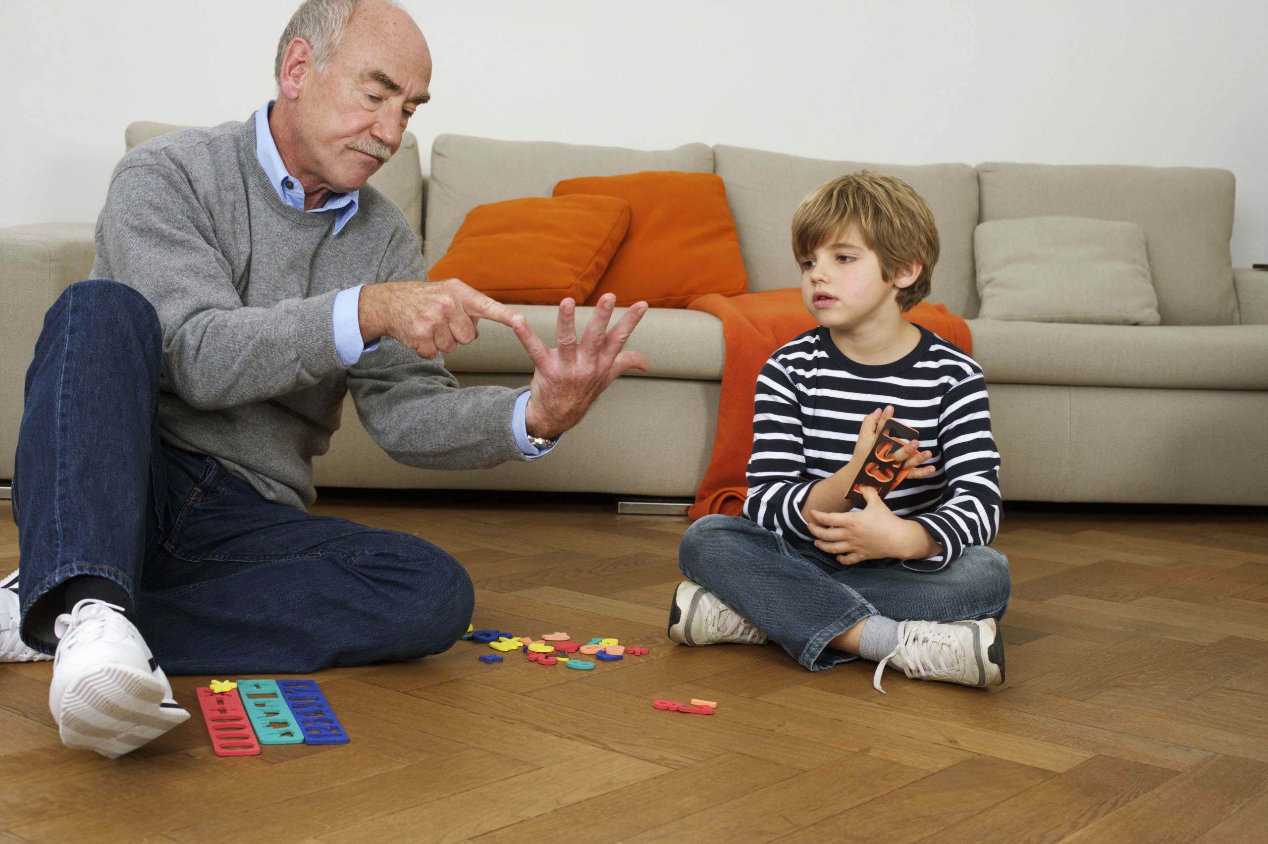 grandfather and grandson 6 years playing on floor 5bef0379c9e77c0051a0c50d